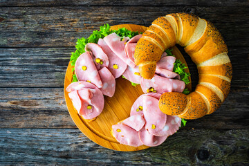 Big sandwich with mortadella with pistachios and lettuce on wooden table