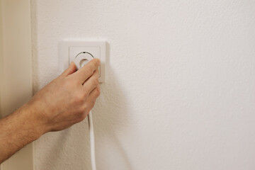 First person view of man's hand puts the charger in the socket