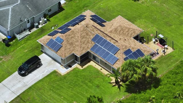 Aerial view of typical american building roof with rows of blue solar photovoltaic panels for producing clean ecological electric energy. Renewable electricity with zero emission concept