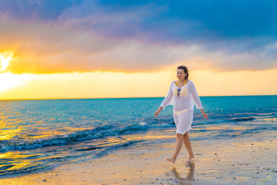Beach holiday - beautiful woman walking on sunny, tropical beach 

