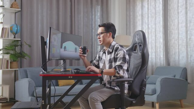 Side View Of Asian Male Automotive Designer Drinking Coffee While Working On 3D Model Of Ev Car On The Desktop Computers At Home
