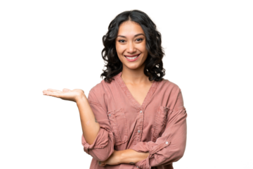 Young Argentinian woman over isolated background holding copyspace imaginary on the palm to insert an ad