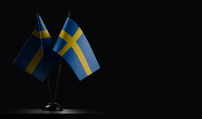 Small national flags of the Sweden on a black background