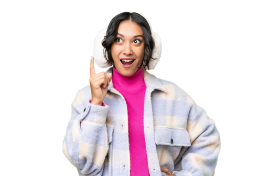 Young Argentinian woman wearing winter muffs over isolated background thinking an idea pointing the finger up