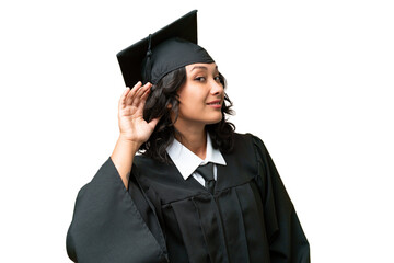 Young university graduate Argentinian woman over isolated background listening to something by putting hand on the ear