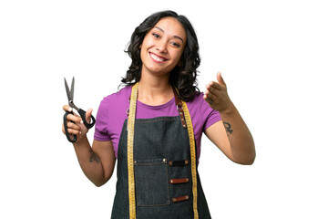 Young seamstress argentinian woman over isolated background shaking hands for closing a good deal