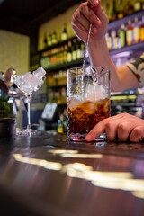 man hand bartender making cocktail in glass on the bar counter