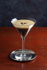 Espresso Martini Made From Vodka, Espresso, and Coffee Liqueur in a Martini Glass on a Wooden Table