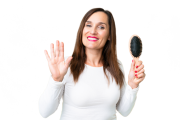 Middle age woman with hair comb over isolated chroma key background saluting with hand with happy expression