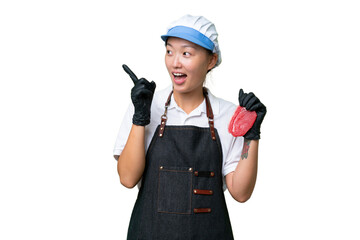 Young caucasian woman wearing an apron and serving fresh cut meat over isolated background intending to realizes the solution while lifting a finger up