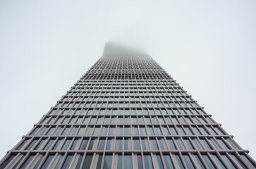 looking up at skyscrapers at a foggy overcast day