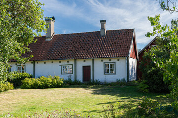 Fototapeta na wymiar Traditional ancient old vintage red Swedish house from wood on a sunny day in summer. Stylish European private house.