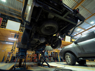 Car on hydraulic lift in auto repair shop