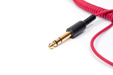 Red cord with a jack for connecting various gadgets, shot on a white background.