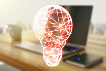 Creative light bulb hologram and modern desk with computer on background, idea concept. Multiexposure