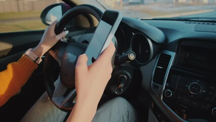 Hands of unrecognizable woman driver using mobile phone while driving car, distracted driving, don't text and drive