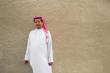 Portrait of an Arabic man with a plain beige wall background