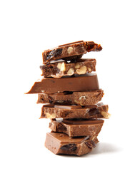 Pieces of chocolate bar with hazelnuts stacked on white background.