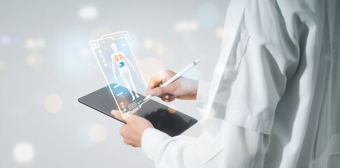 The doctor is working on a digital tablet for health records in the medical office. The concept is to evaluate and care for patients' health online.