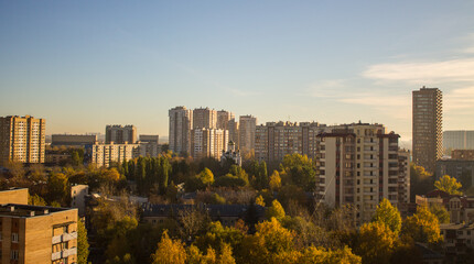Fototapeta premium Urban beautiful landscape - panoramic view of residential multi-storey modern houses among autumn trees on a sunny October day in Reutov Moscow region and copy space