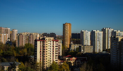 Urban beautiful landscape - panoramic view of residential multi-storey modern houses among autumn trees on a sunny October day in Reutov Moscow region and copy space