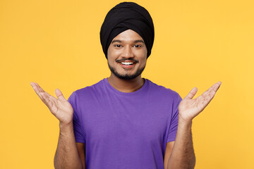 Surprised excited devotee Sikh Indian man ties his traditional turban dastar wear purple t-shirt...