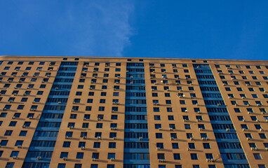 A wall with windows of a modern multi-storey house in a close-up in Reutov near Moscow and a space for copying on a sunny day