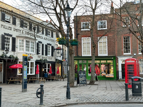 London, UK - 06.02.2023. Richmond Upon Thames area, The Green view and The Prince's Head pub, West London. Selective focus. Horizontal. England. Red telephone box. winter in London.