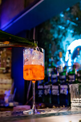 man hand bartender making sweet and sour refreshing Aperol Spritz cocktail on the bar counter