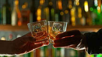 Close-up view of a two whiskey shots in hands.