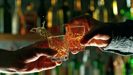 Close-up view of a two hard liquor shots in hands. - obrazy, fototapety, plakaty