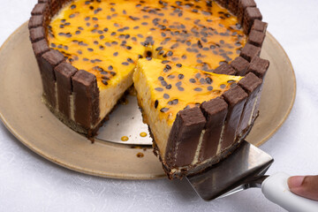 slice of passion fruit tart decorated with chocolate cookies onwhite background