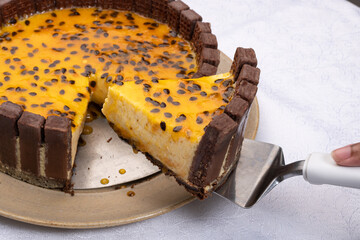 slice of passion fruit tart decorated with chocolate cookies onwhite background