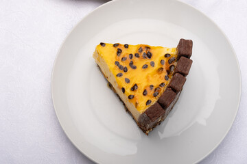 slice of passion fruit tart decorated with chocolate cookies onwhite background