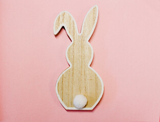 wooden rabbit on a pink background in the middle , colour of the year 2022 , top view, easter bunny
