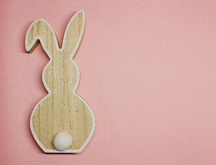 wooden rabbit on a pink background, colour of the year 2022 , top view on the left, copies space