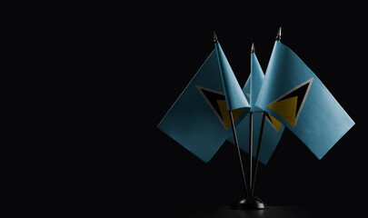 Small national flags of the Saint Lucia on a black background
