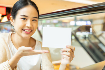 Happy smiling woman showing blank paper card, concept education, tutoring, language learning
