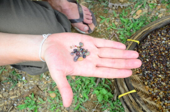 Human hand with precious stones on the background of a wicker basket in Sri Lanka