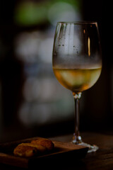 a glass of white wine in a dark room