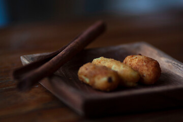 potato fingers snack on a wooden plate decorated with a cinnamon stick