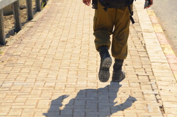 Israeli soldier without a face. Only boots. Soldier walking on asphalt. Soldiers IDF - Israel...
