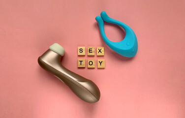 Sex toys. Two vibrators on a pink background. lettering SEX TOY. Useful for sex shop
