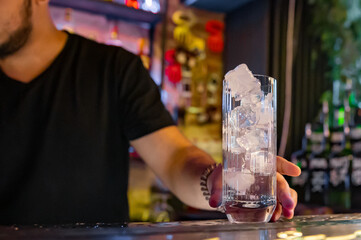 empty glass with ice on a bar counter in bar or pub