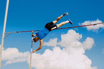 athlete pole vaulter in pole vaulting competition background blue sky - obrazy, fototapety, plakaty