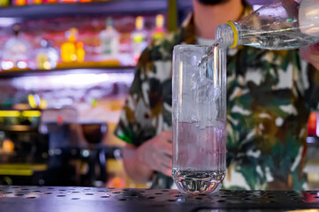 man bartender making cold gin tonic cocktail in bar