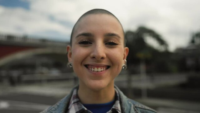 Shaved head girl smiling in front camera