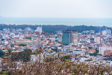 Morning in Vung Tau seen from above, with the most beautiful sea waves, coastline, streets, buidling, coconut trees and Tao Phung mountain in Vietnam. Travel concept.
