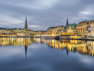 Hamburg city centre illuminated on lake Binnenalster at dusk, Germany