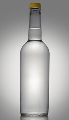 A bottle, full of gin, vodka or tequila on a reflective surface. Dummy for the product design.